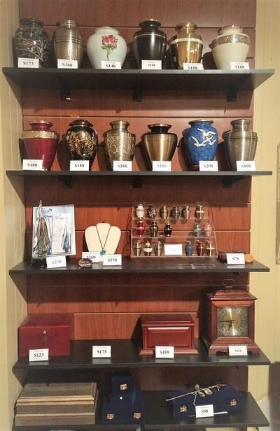 Shelves of assorted decorative urns and vases displayed in a shop or museum cabinet