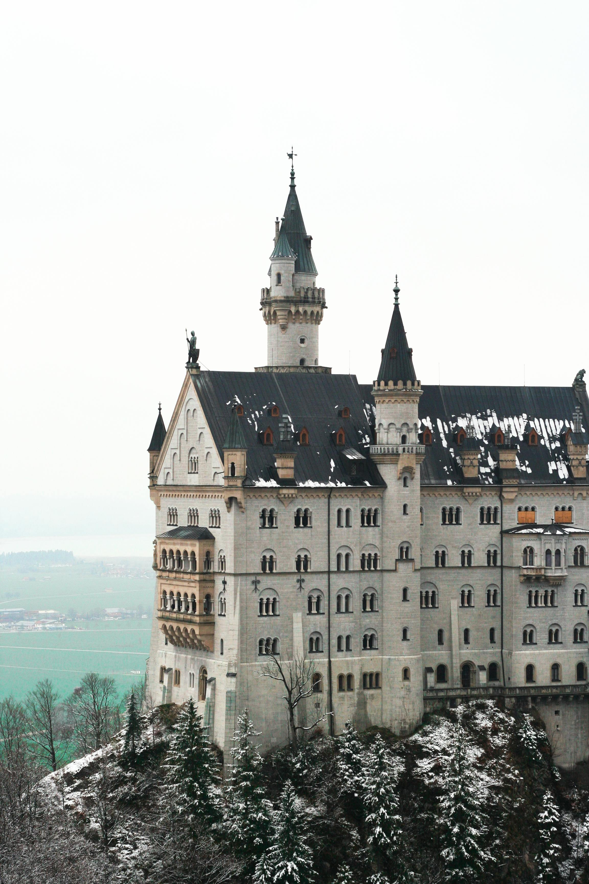 Auf einem schneebedeckten Hügel steht ein großes Schloss.