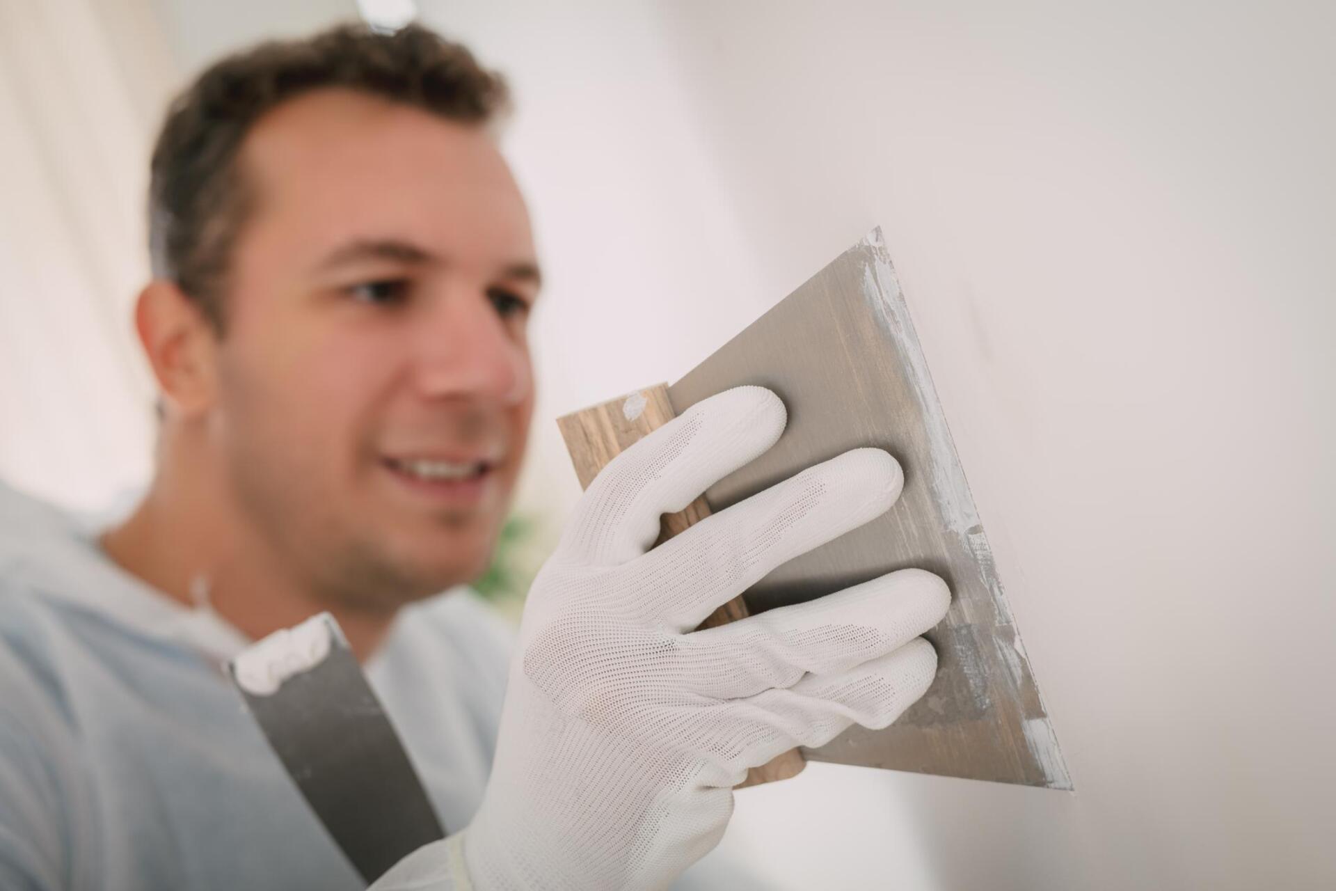 man scraping the paint