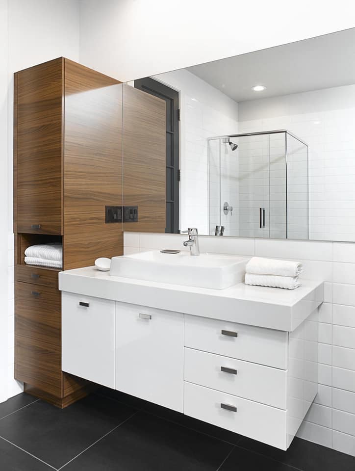 Une salle de bain avec lavabo , miroir et cabine de douche.