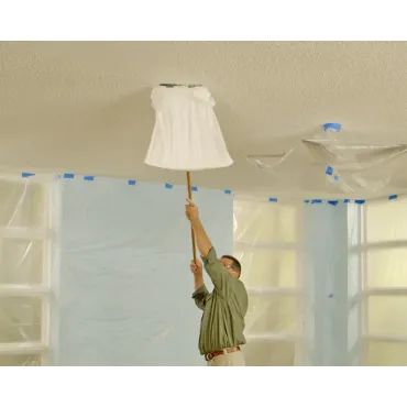 A contractor covers and preps a ceiling before popcorn removal.