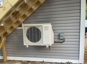 Air source heat pumps installed on the outside of a modern house