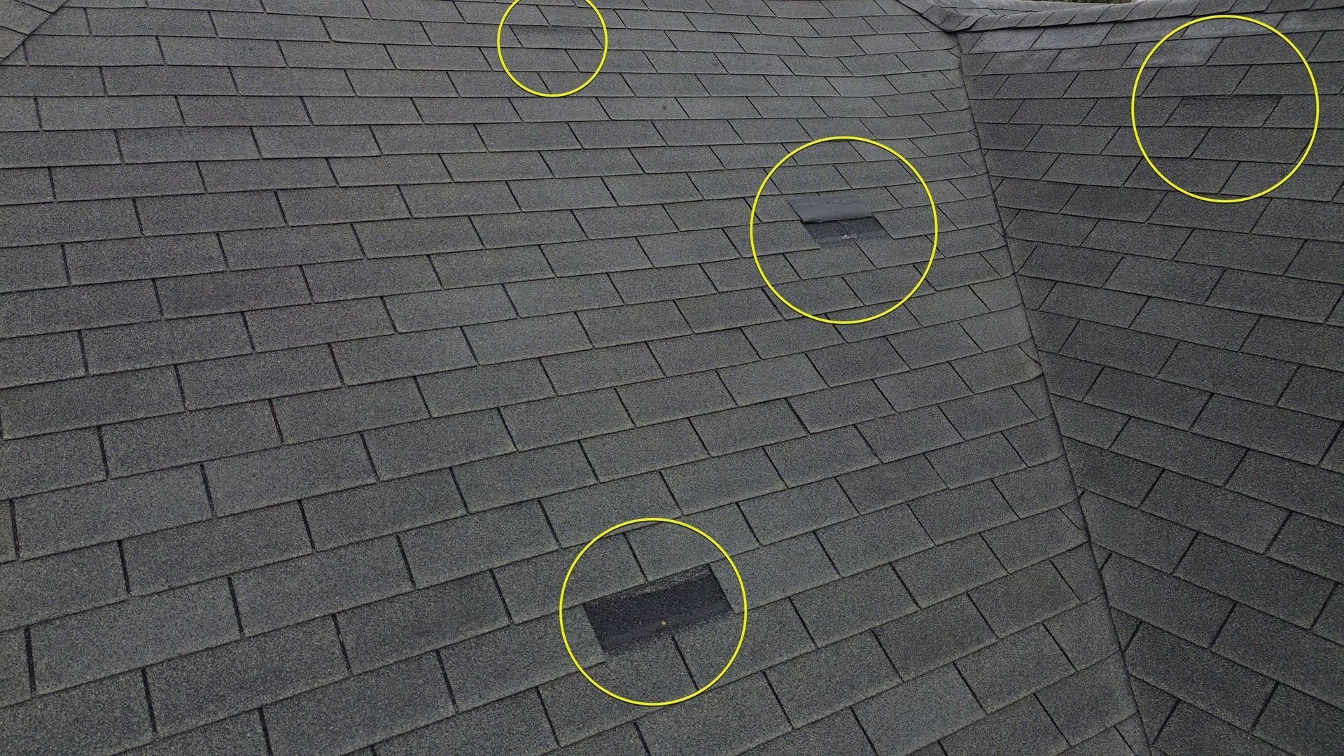 Roof with wind-damaged shingles after a summer storm in Georgia