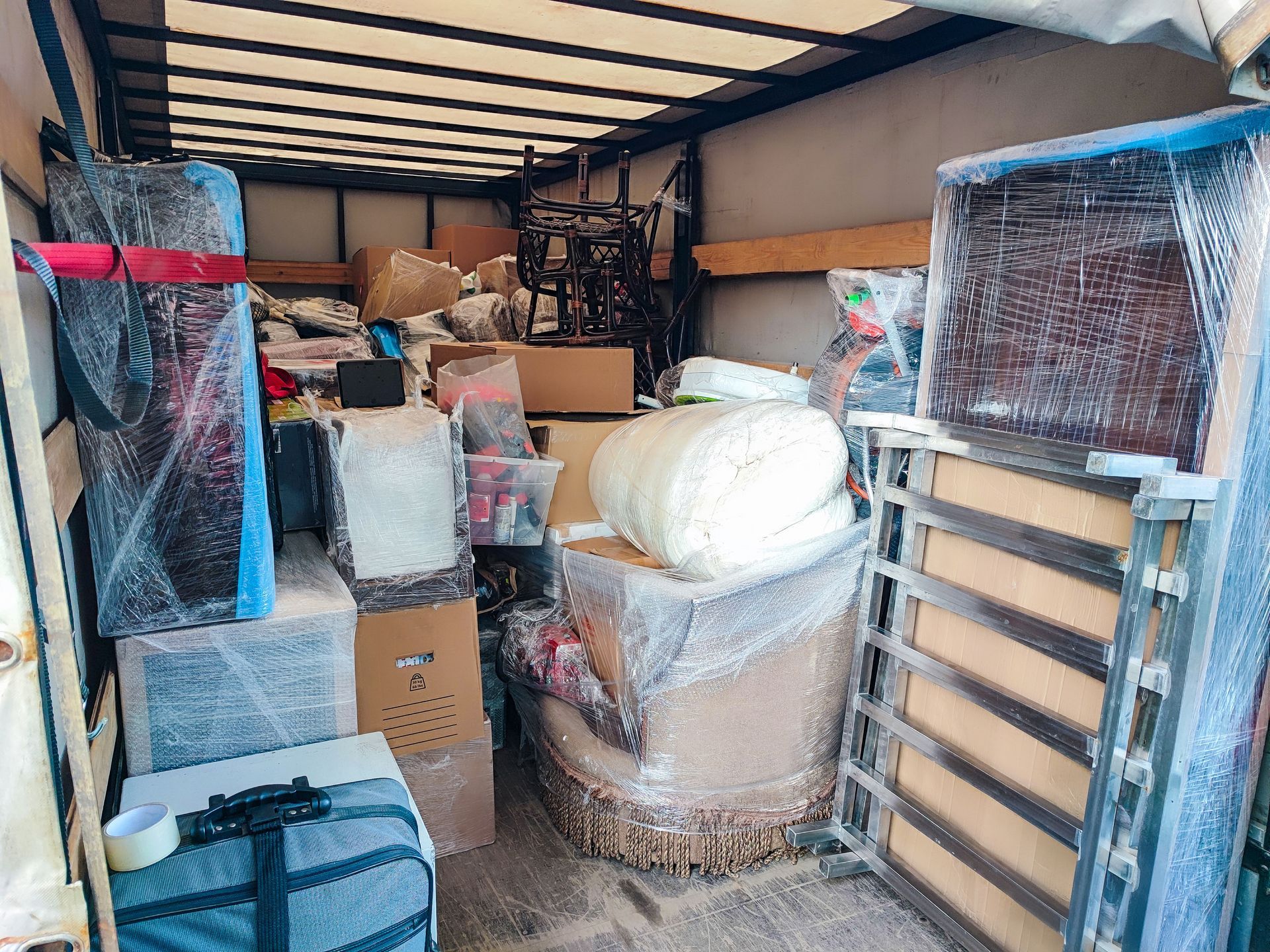 Packed moving truck interior with wrapped furniture and boxes secured tightly inside Packed moving truck interior with wrapped furniture and boxes secured tightly inside
