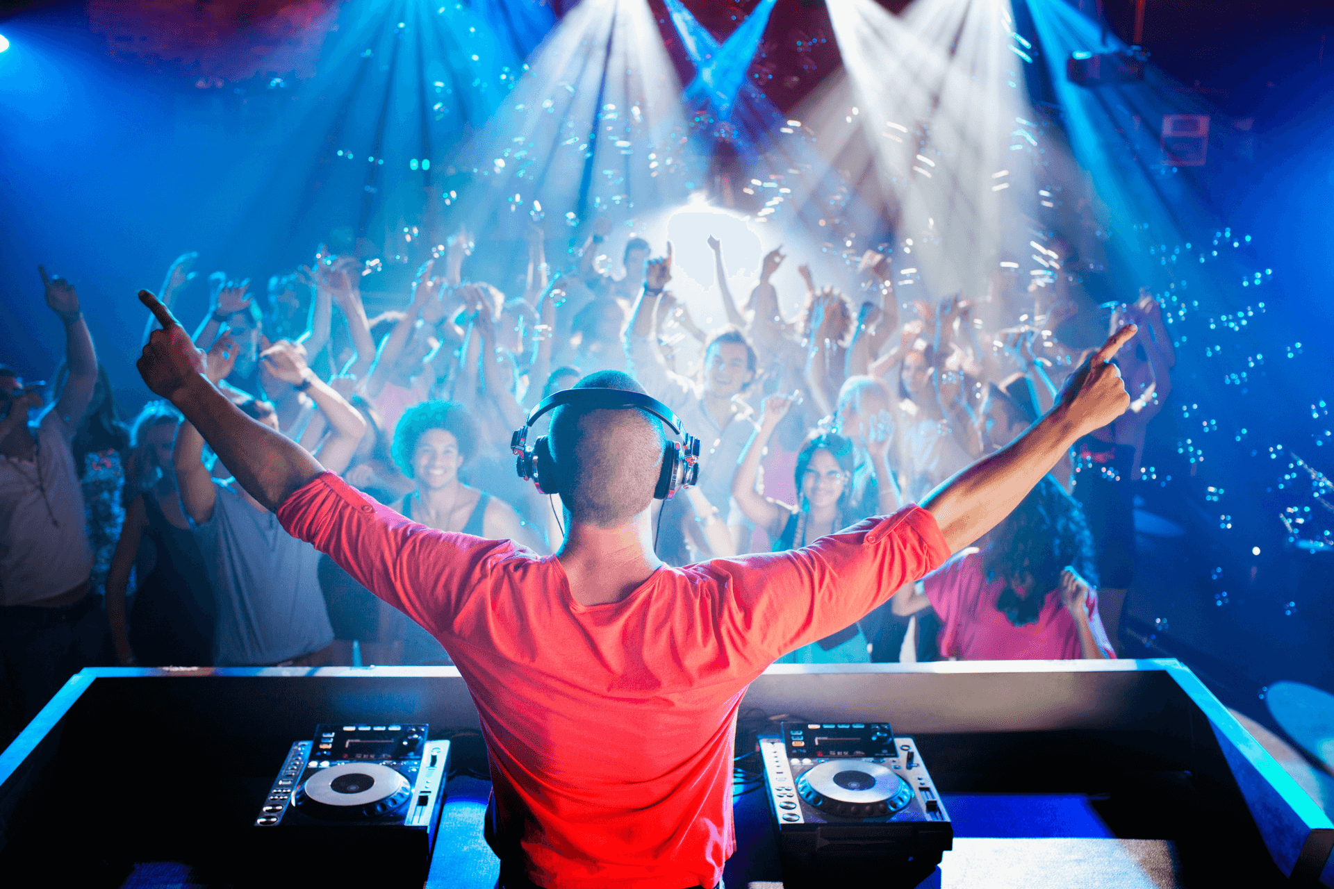 A dj is playing music in front of a crowd at a party.