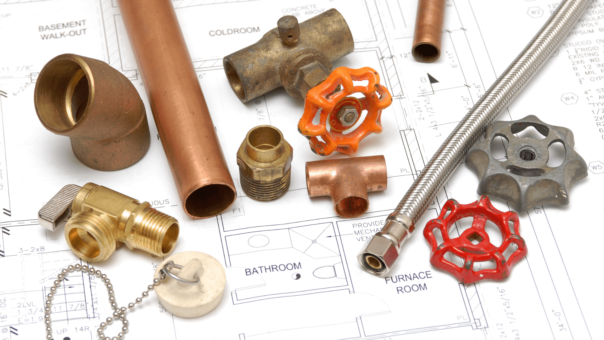 A bunch of pipes and valves are sitting on top of a blueprint.