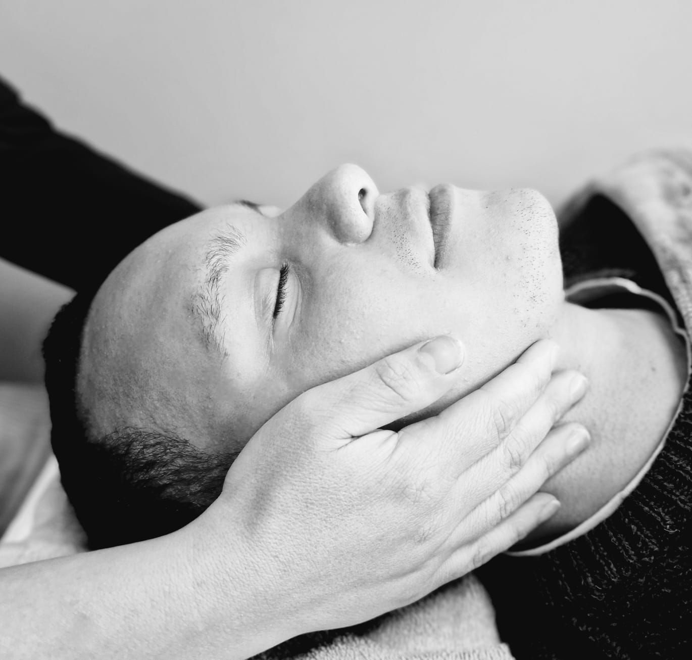 Een zwart-witfoto van een man die een massage krijgt
