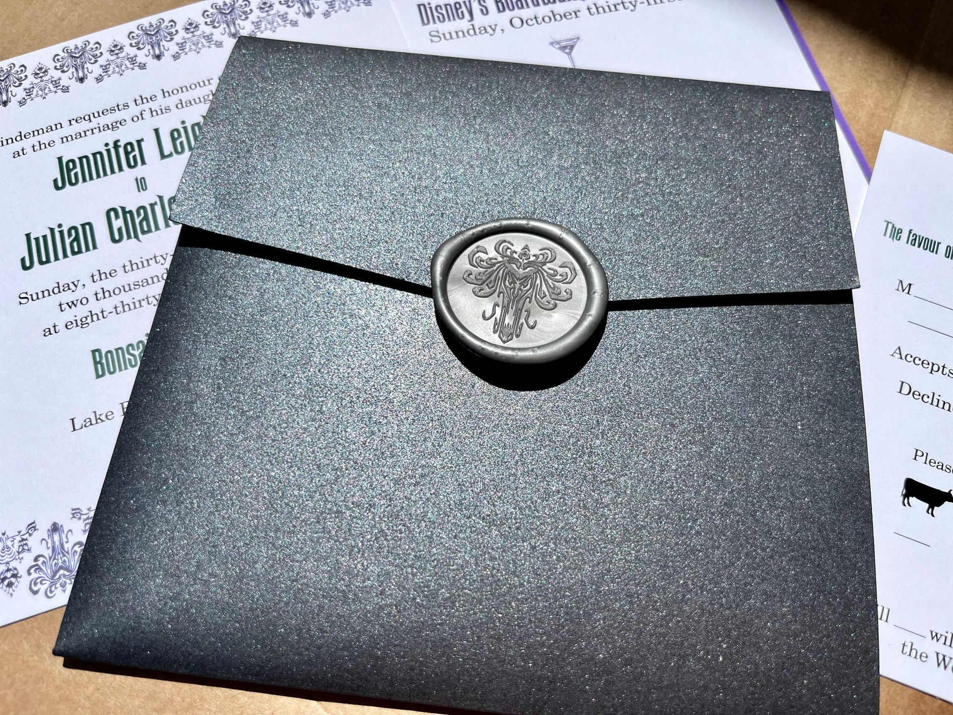 a wedding invitation for julian and jennifer leigh that is enclosed in a pocketfold with a custom wax seal
