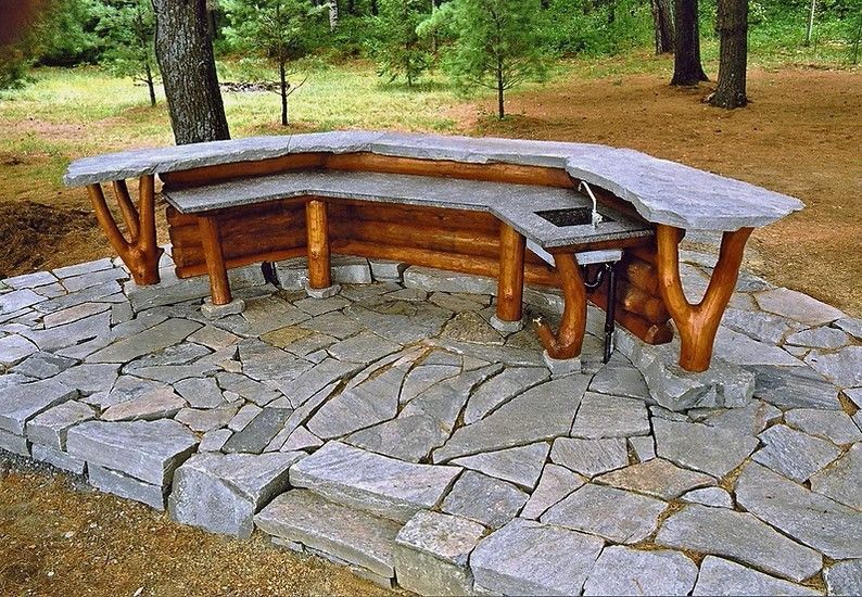 Curved wooden and stone bar top with stone bar stools.