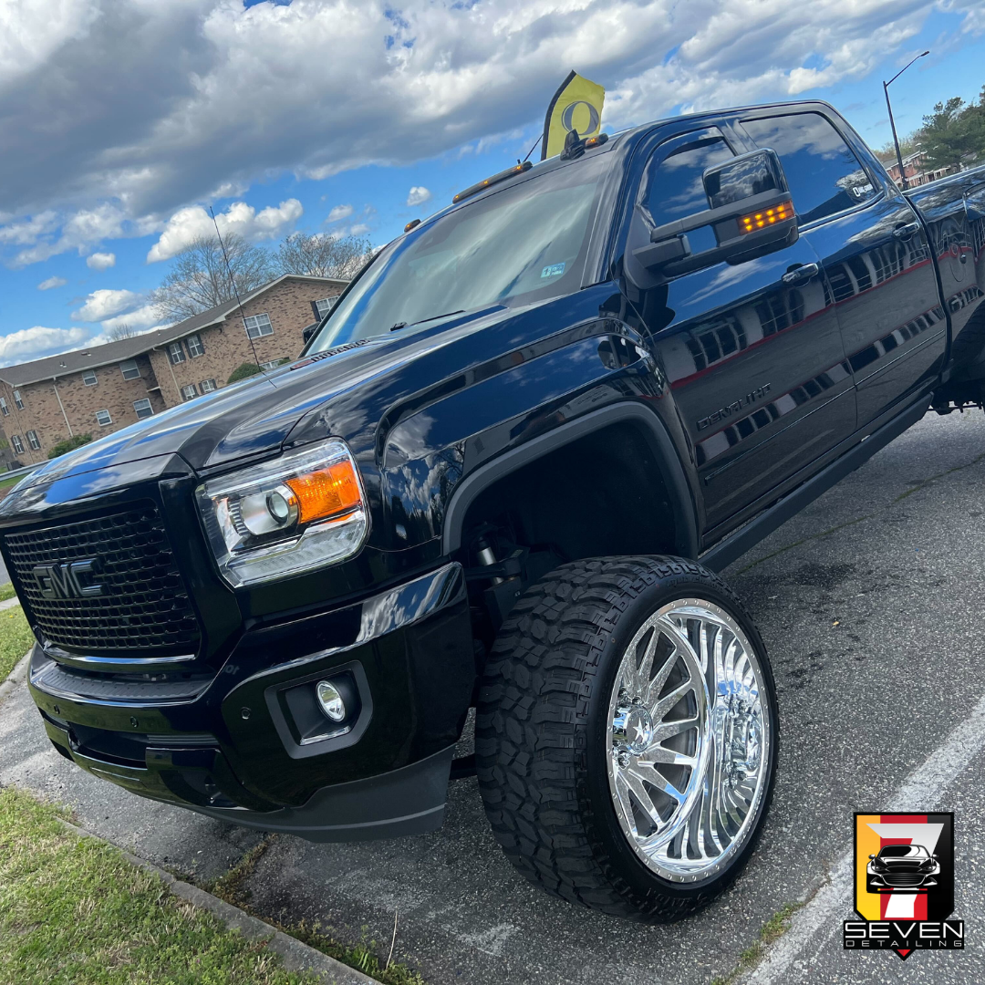 A black truck car parked after being detailed by a mobile detailing company.