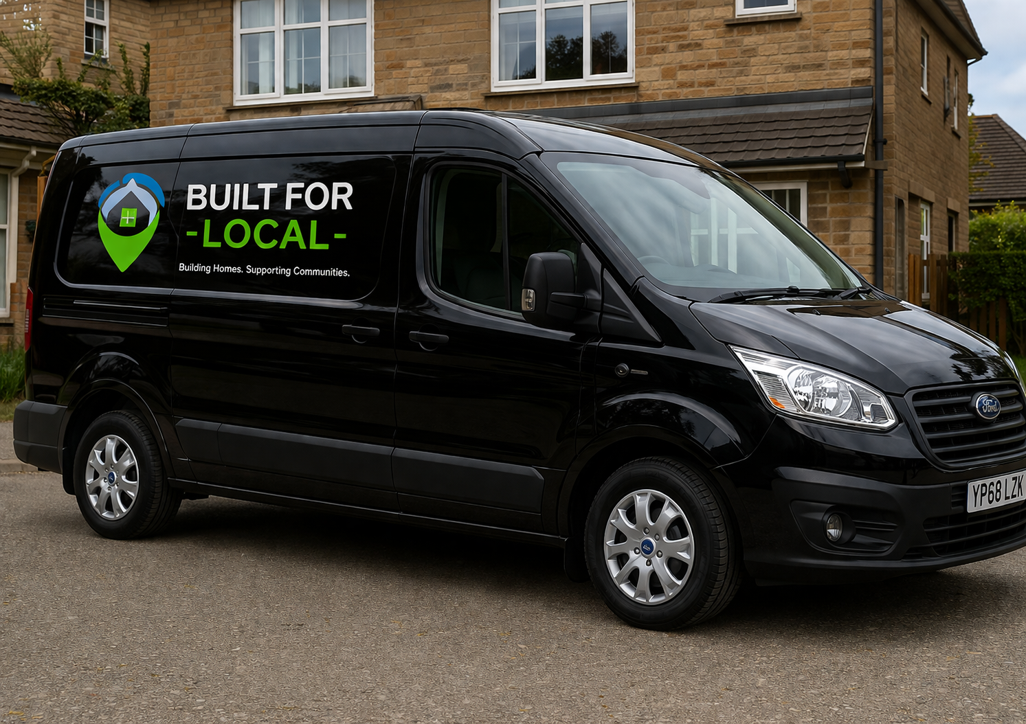 Black van parked outside a brick house with Built for Local logo on the side