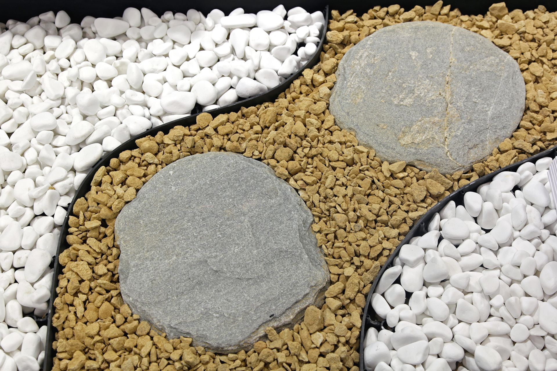 Decorative garden bed with white and tan gravel, gray stepping stones. Decorative garden bed with white and tan gravel, gray stepping stones.