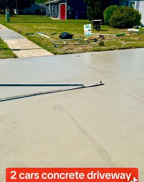 Newly poured concrete driveway in front of a house.