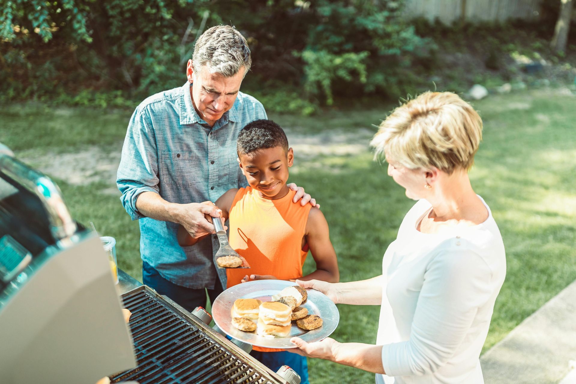 A family is having a barbecue in their backyard.