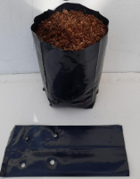 Una bolsa de plástico negra llena de tierra al lado de una bolsa de plástico negra.