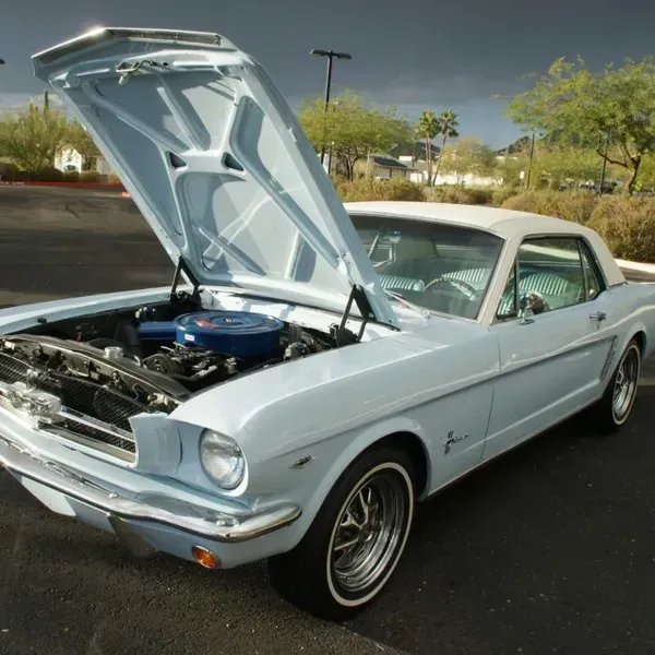 a light blue mustang with the hood open