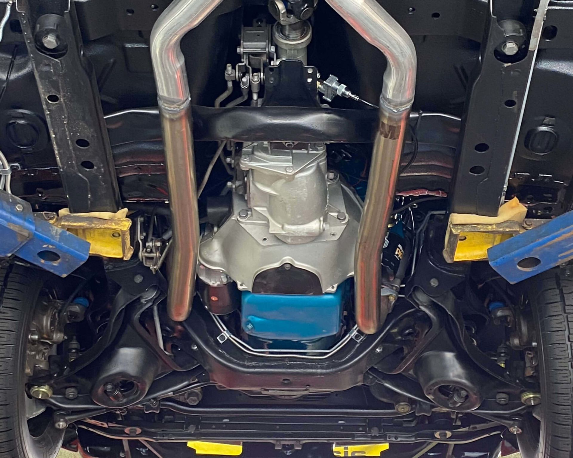 a close up of the underside of a car showing the engine and transmission