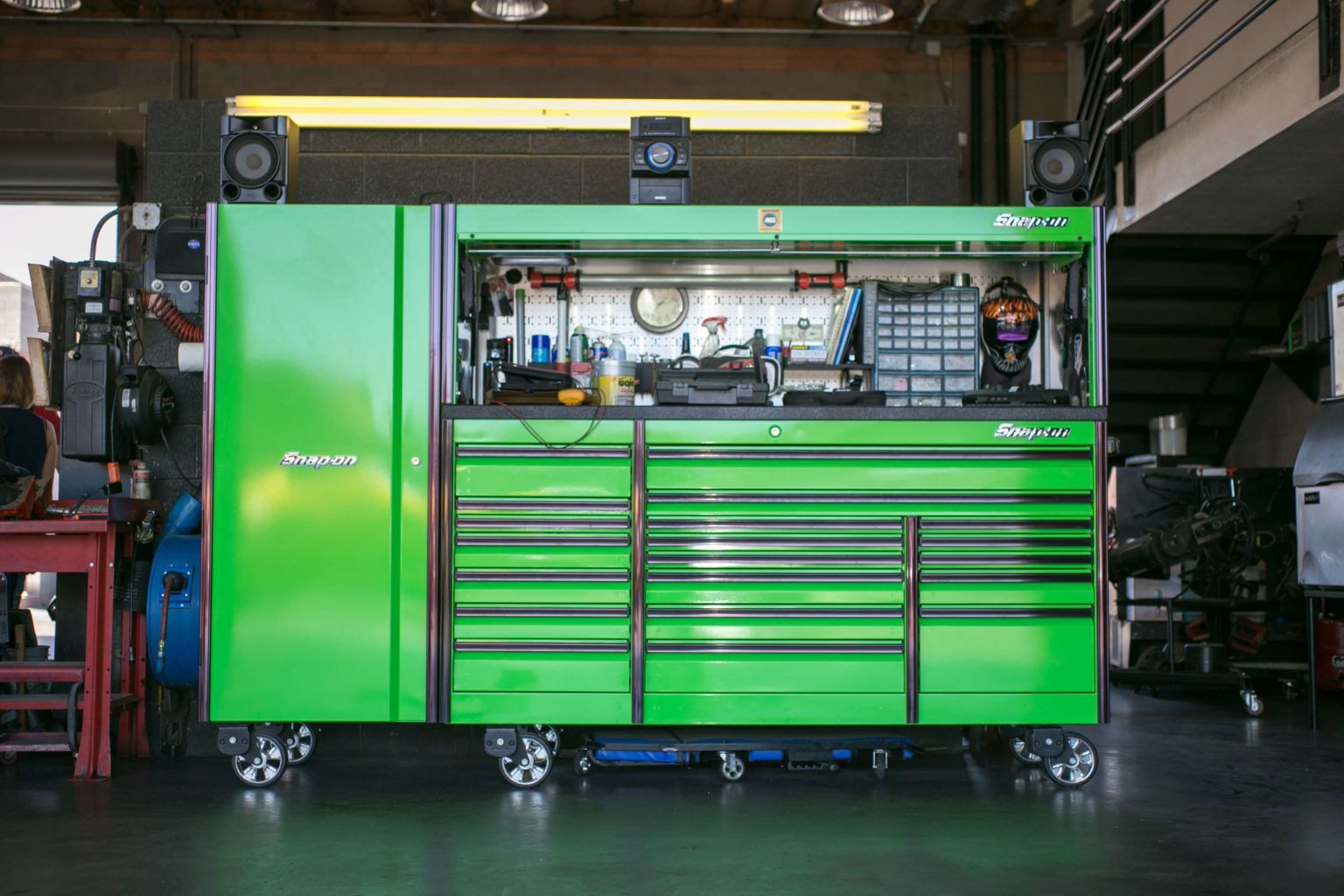 A green toolbox is sitting in a garage.