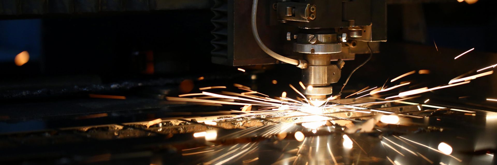 a machine is cutting a piece of metal with sparks coming out of it .