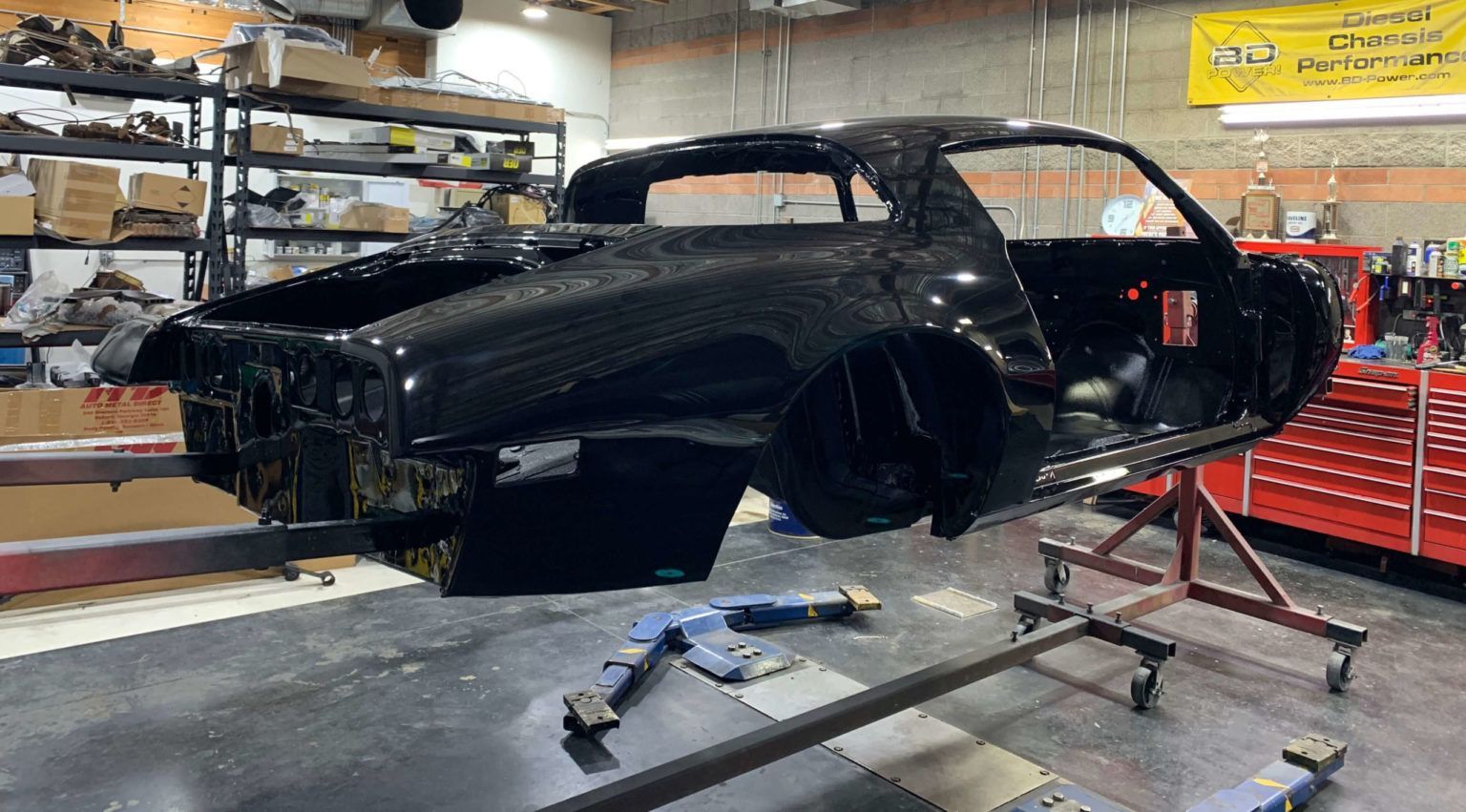 A black car is being built in a garage.