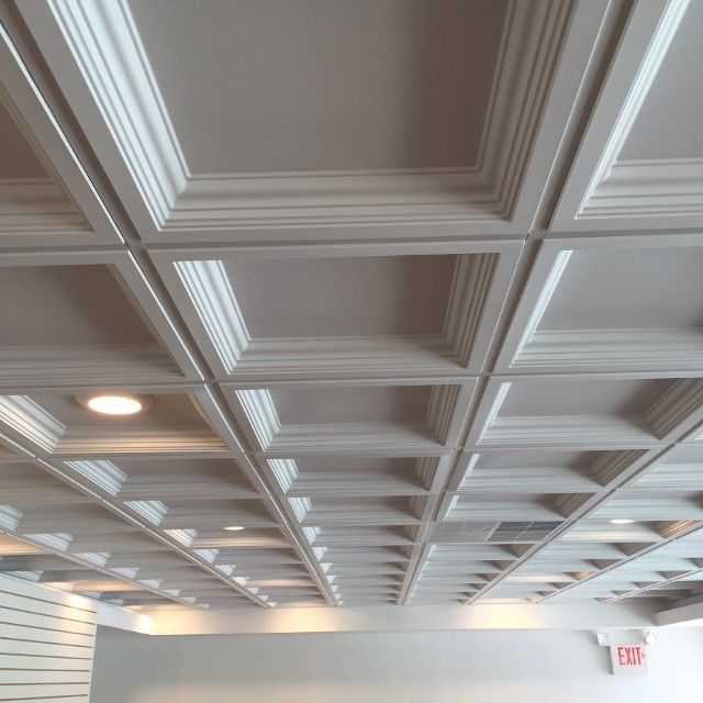 White coffered ceiling with recessed lighting.