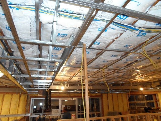 Open ceiling construction, metal framing, insulation, and electrical wiring. Yellow insulation in the walls.
