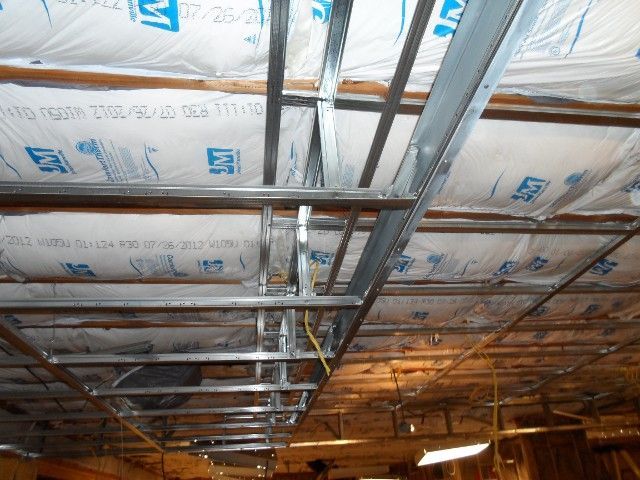 Metal framing for a ceiling with insulation and wiring visible.