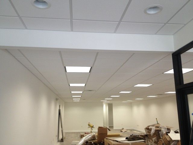 White office interior with drop ceiling, recessed lighting, and empty space.