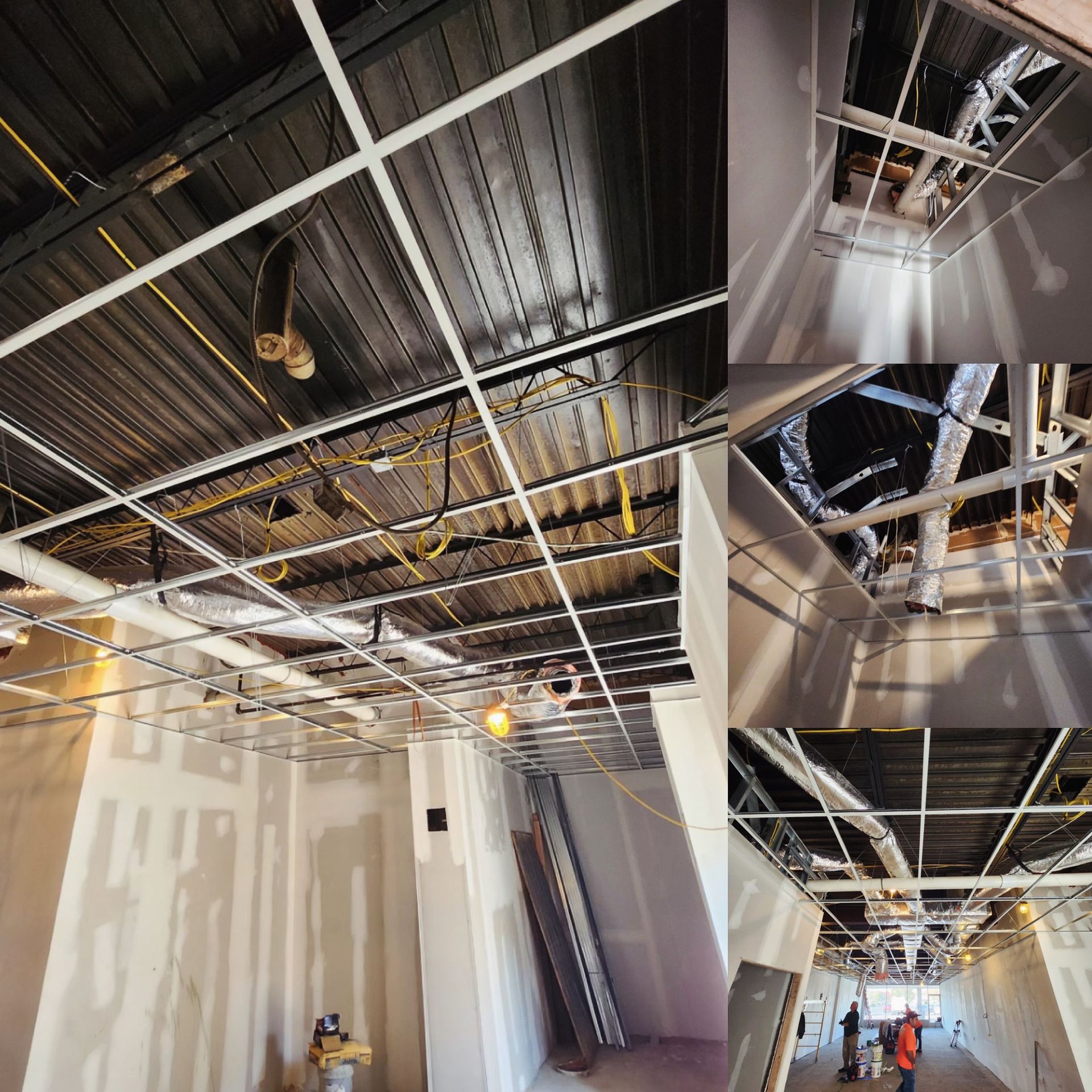 Construction site with exposed ceiling grid, ductwork, and partially built walls.