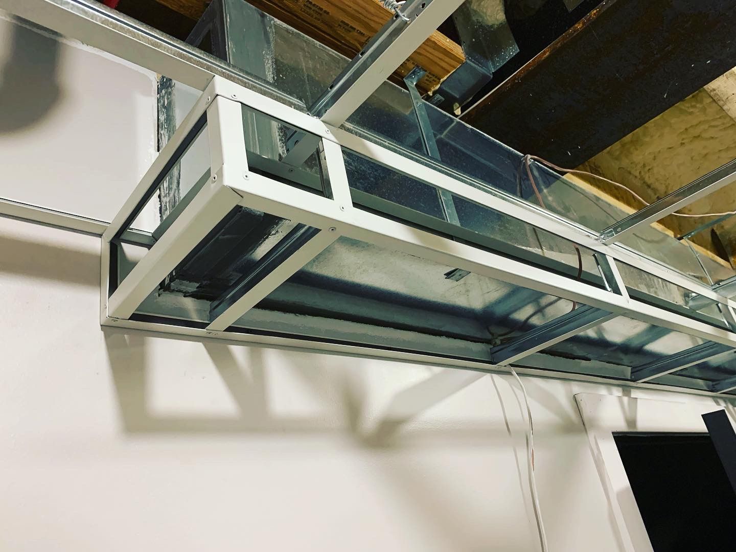 Metal framework suspended from a ceiling, potentially for ductwork or lighting.