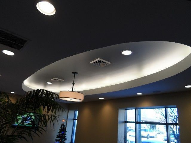 Interior view with recessed lighting and oval ceiling feature; pendant light hangs below.