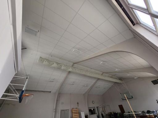 White ceiling with a curved section and large windows.