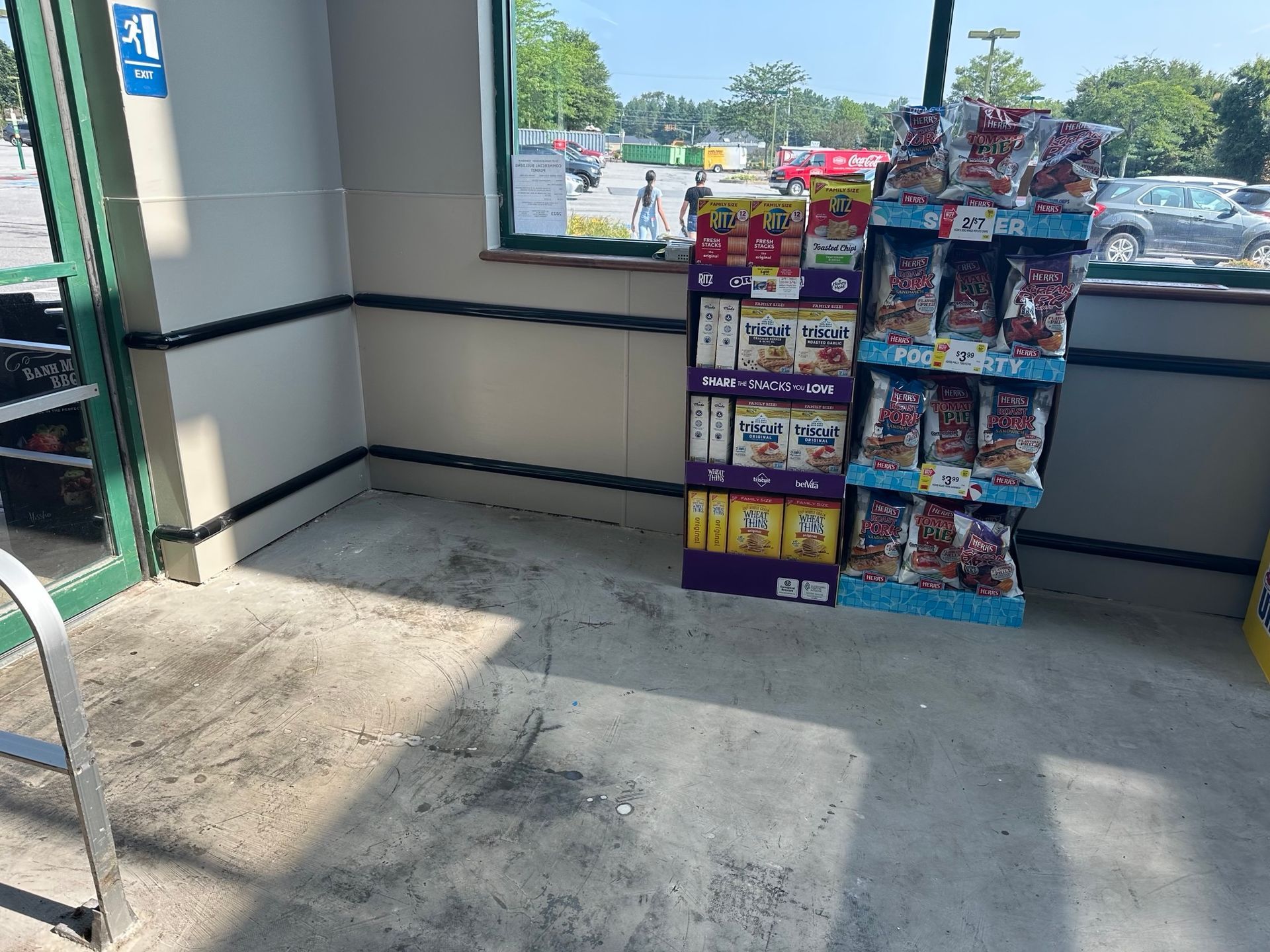 Interior of a store entrance. A display of snacks sits beside a window.