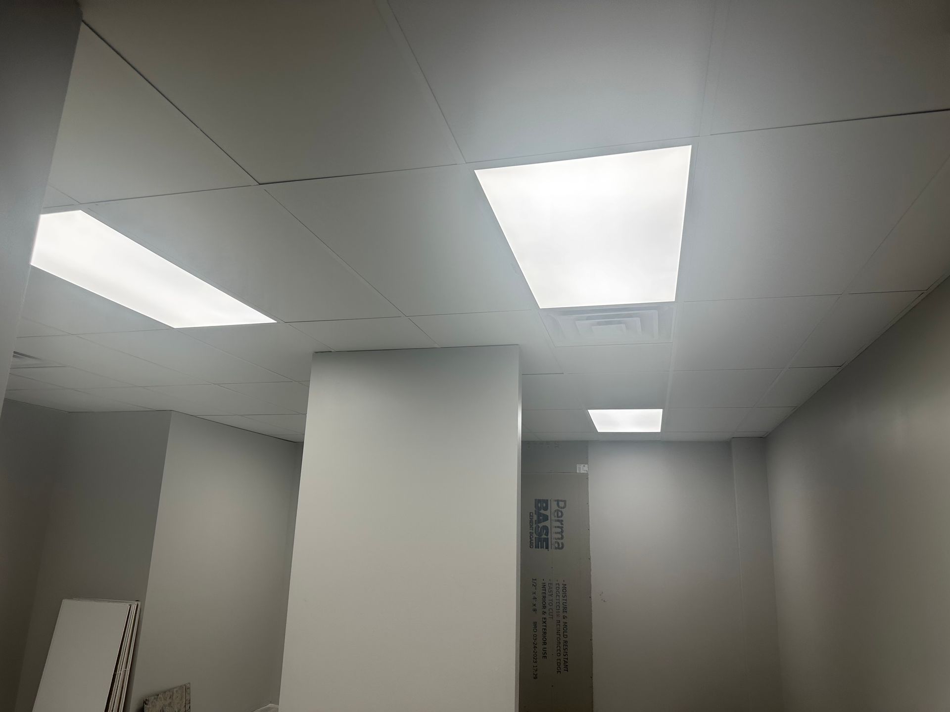 An interior office space with bright ceiling lights and a white column in the center.