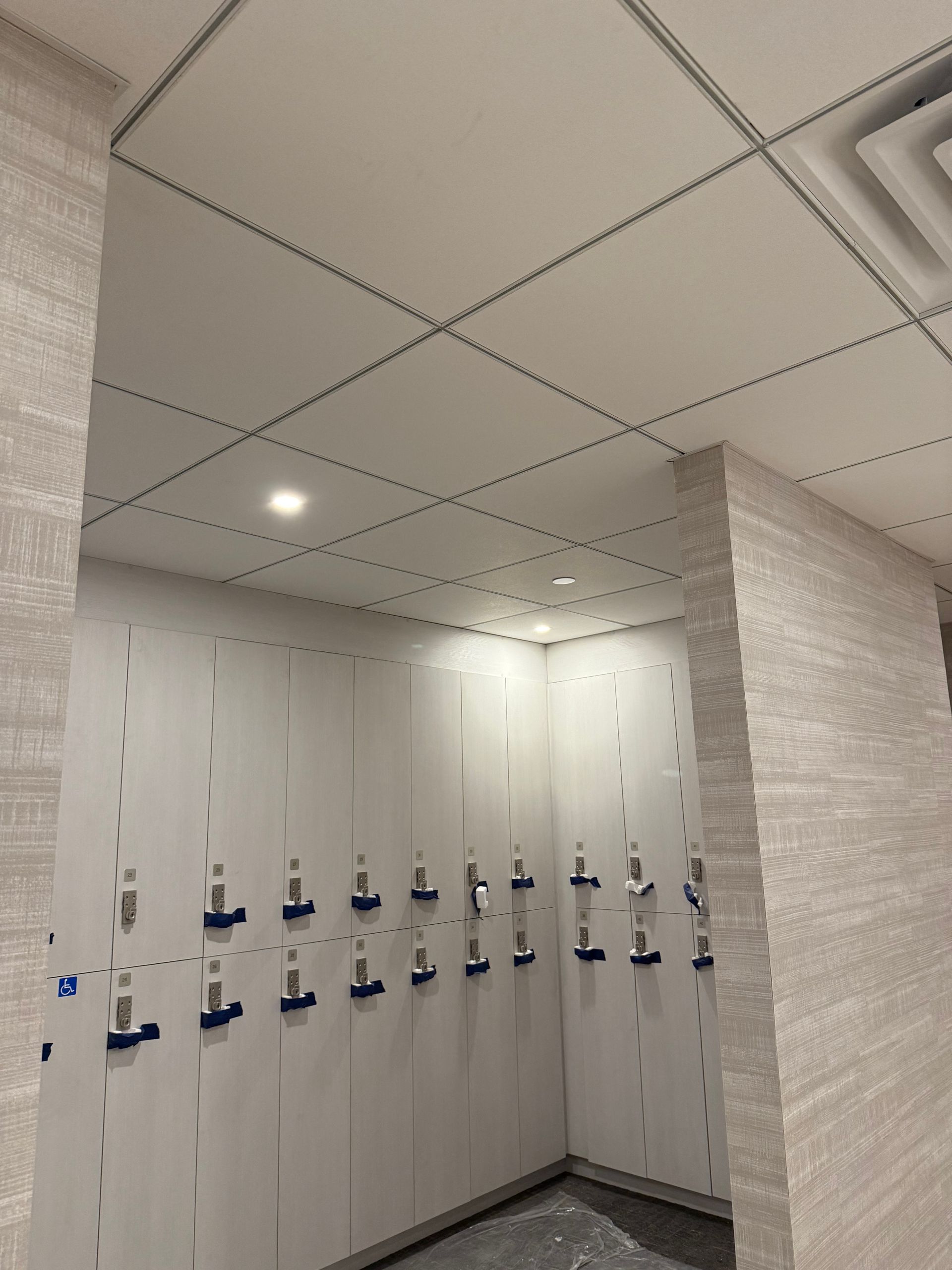 Lockers in a room with textured walls and ceiling. Some lockers are closed, others are open.