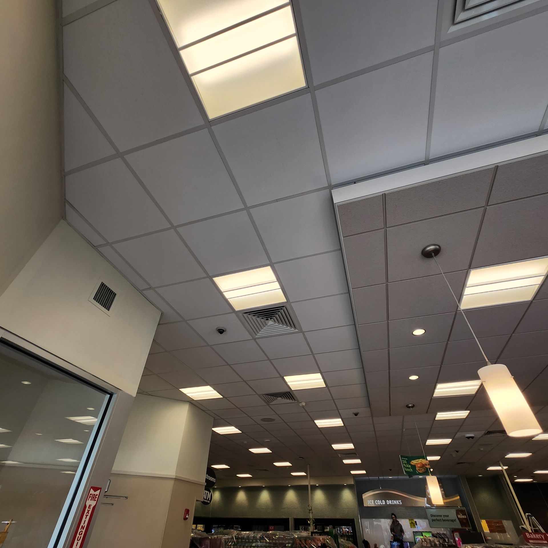 A tiled ceiling with recessed lighting in a commercial building.