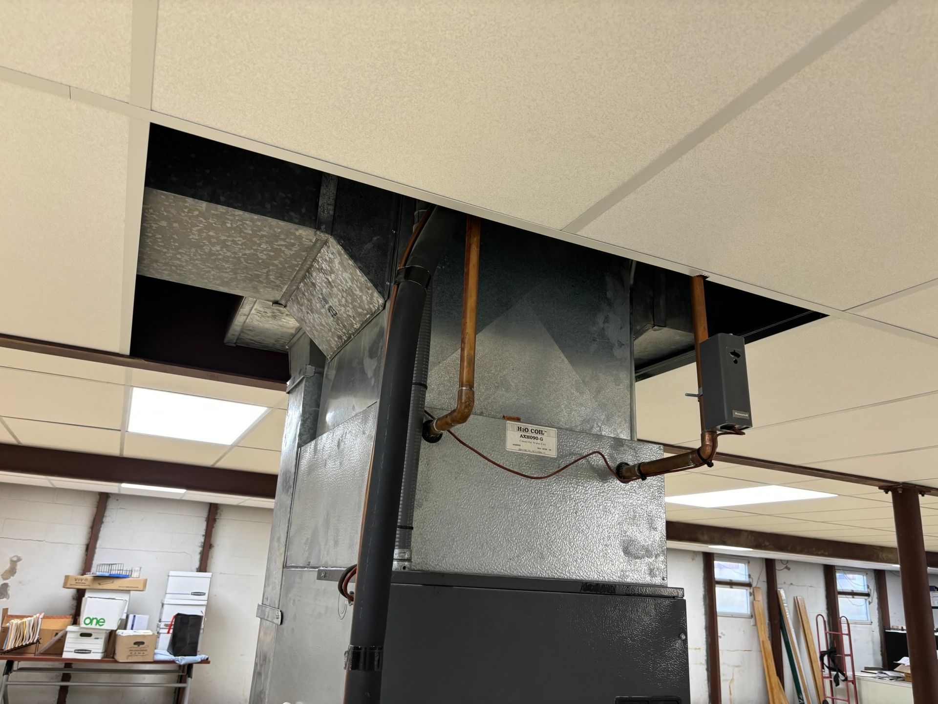 HVAC system in a commercial setting, with ductwork extending from a dropped ceiling.