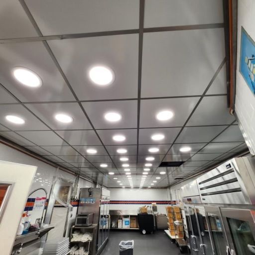 Interior view of a food truck kitchen with bright ceiling lights and stainless steel equipment.
