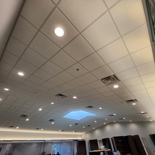 White ceiling with recessed lighting, skylight, and ventilation grates.