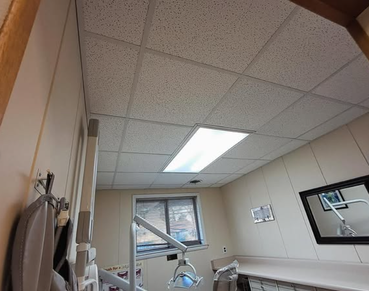 Dental operatory with ceiling lights, window, and dental equipment.