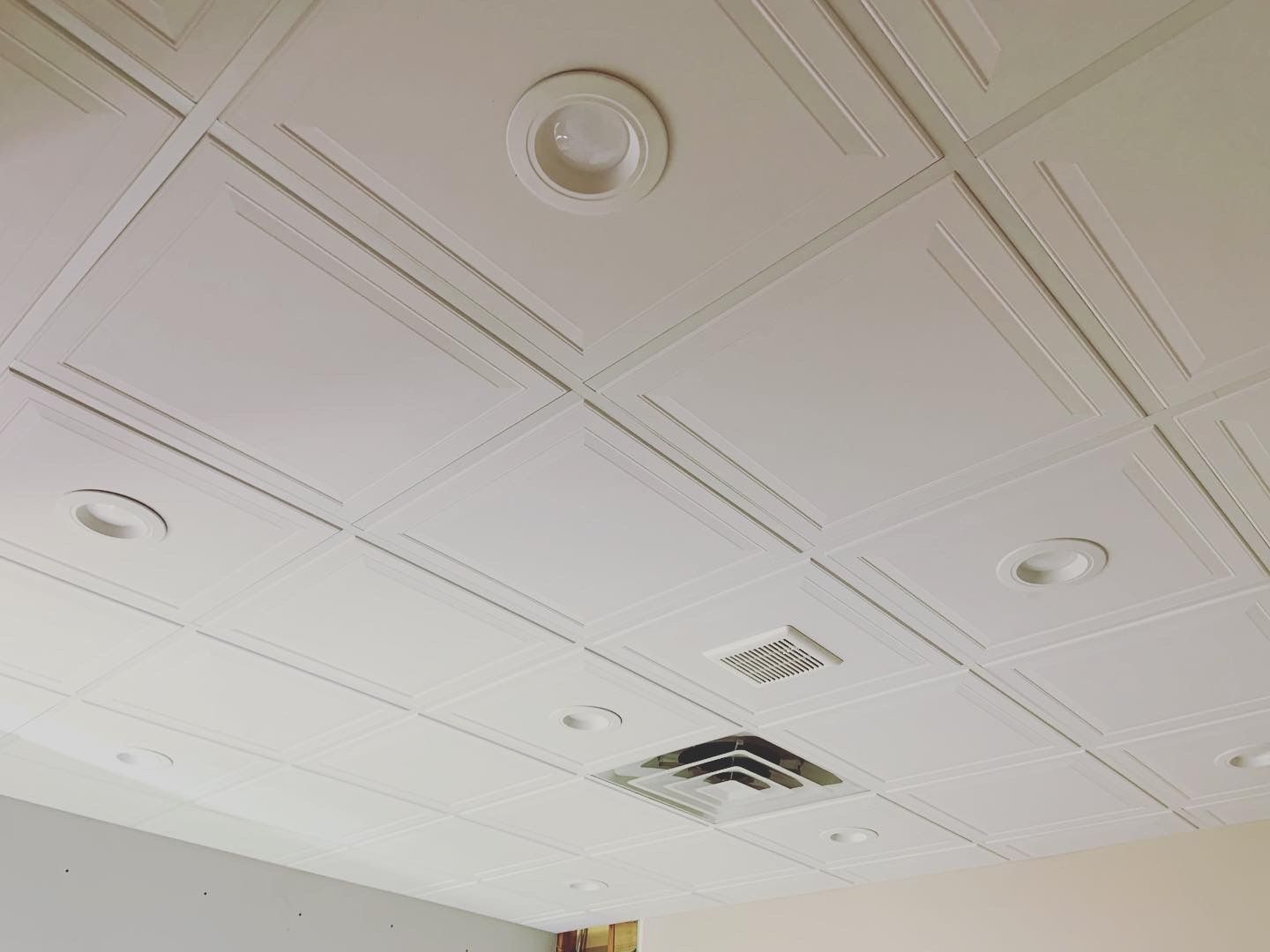 White drop ceiling with recessed lights and air vents.