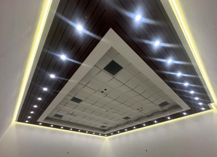 Ceiling with recessed lights, wooden panels, and a contrasting central section.