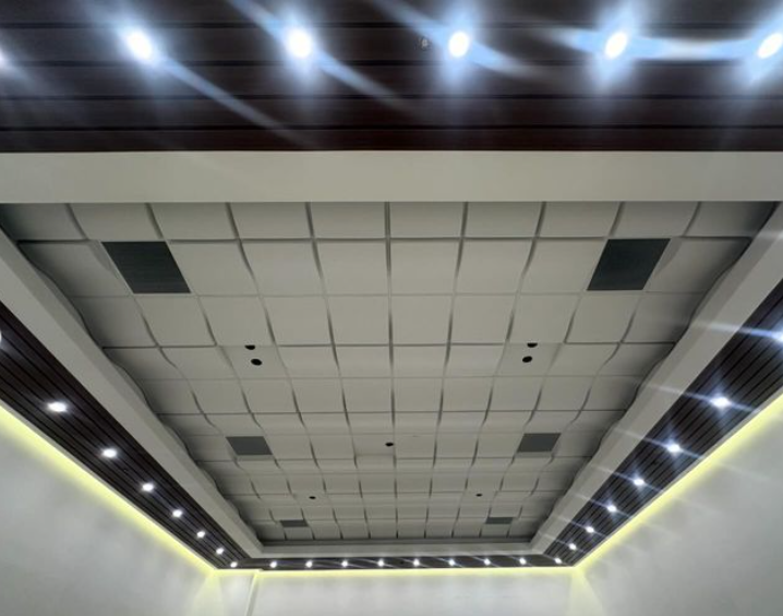 Ceiling with a grid of panels, recessed lights, and dark wood trim.