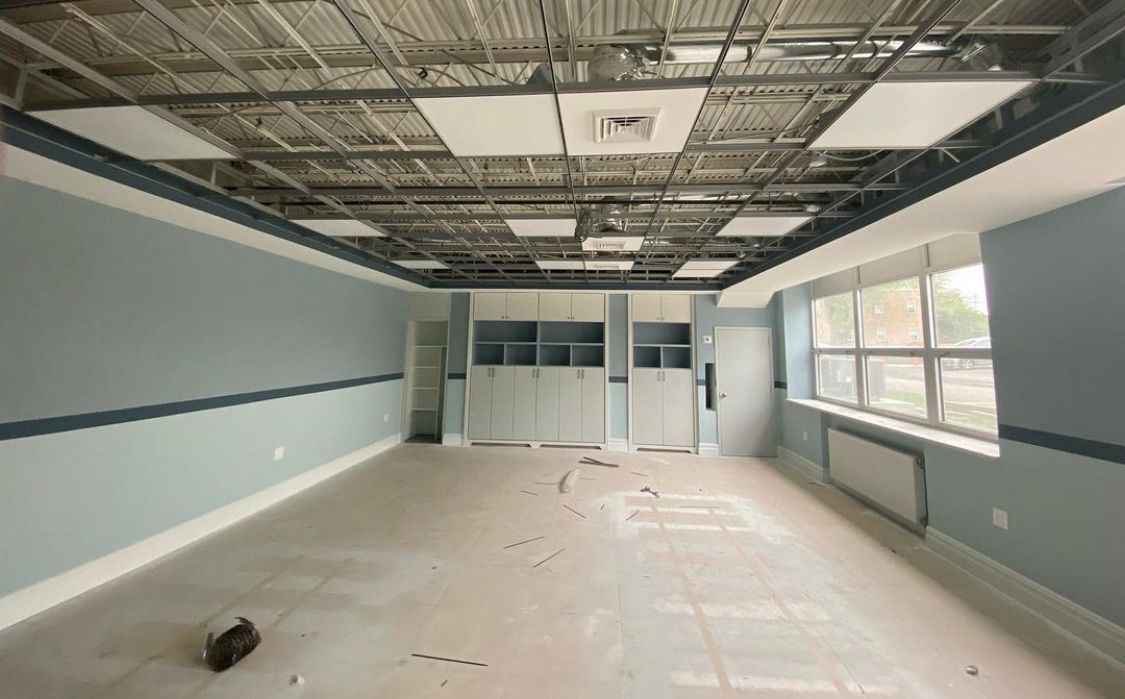 Empty room with blue walls, open ceiling, and built-in cabinets.