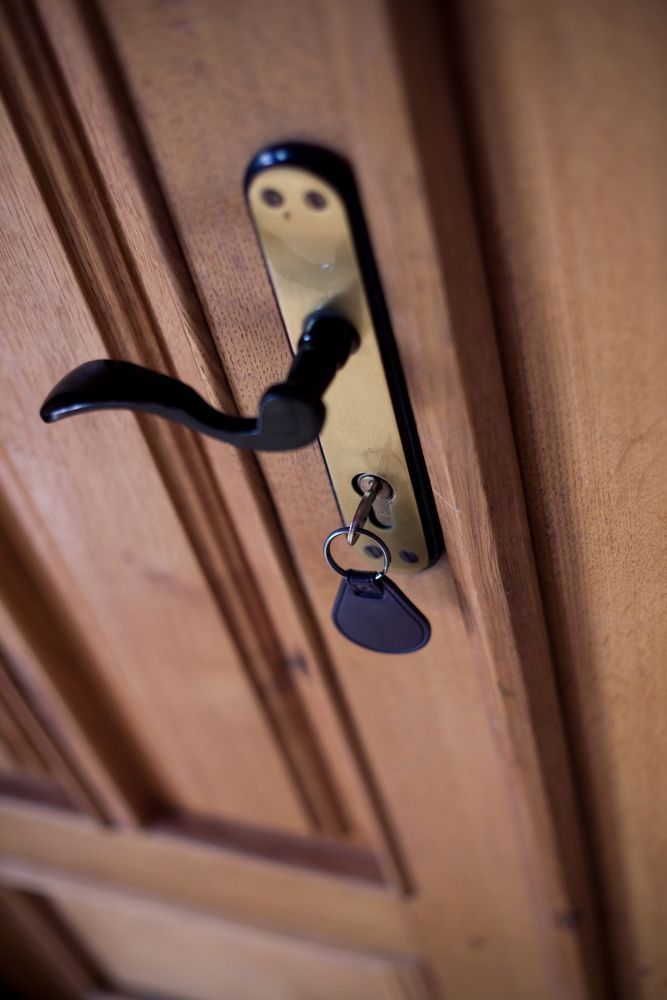 Locked door with key in lock and old-styled handle — Locksmith in Carrara, QLD