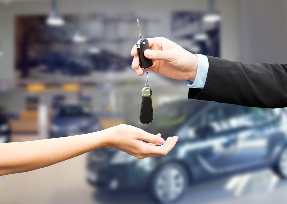 Close up of car salesman giving key — Locksmith in Varsity Lakes, QLD