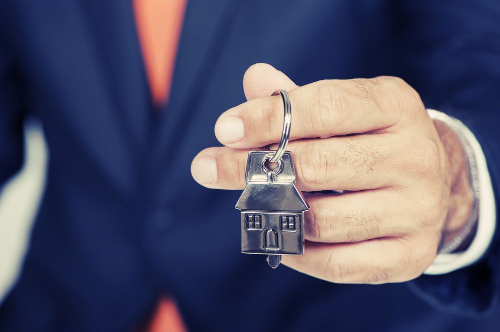 Real estate agent handing over house keys — Locksmith in Clear Island Waters, QLD