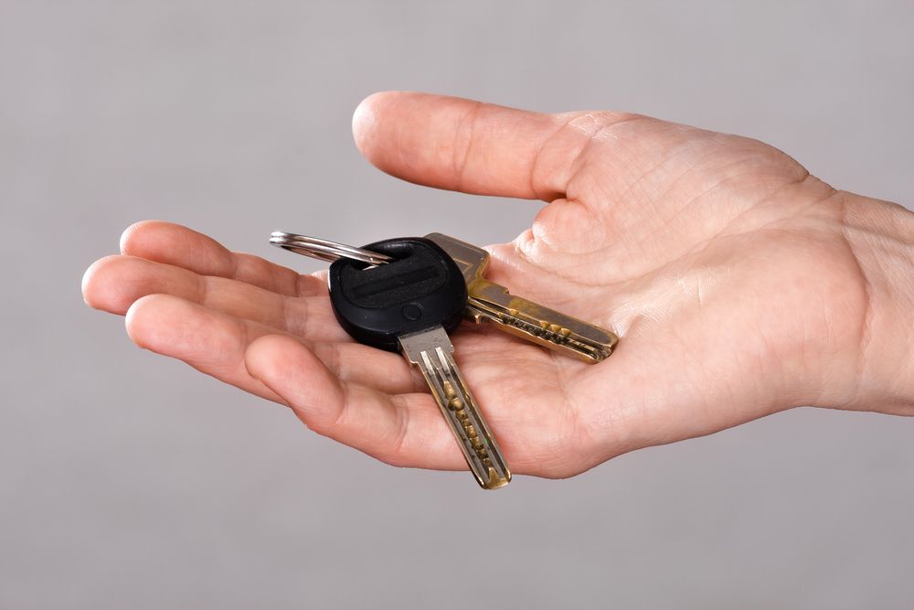 Man holding key — Locksmith in Varsity Lakes, QLD