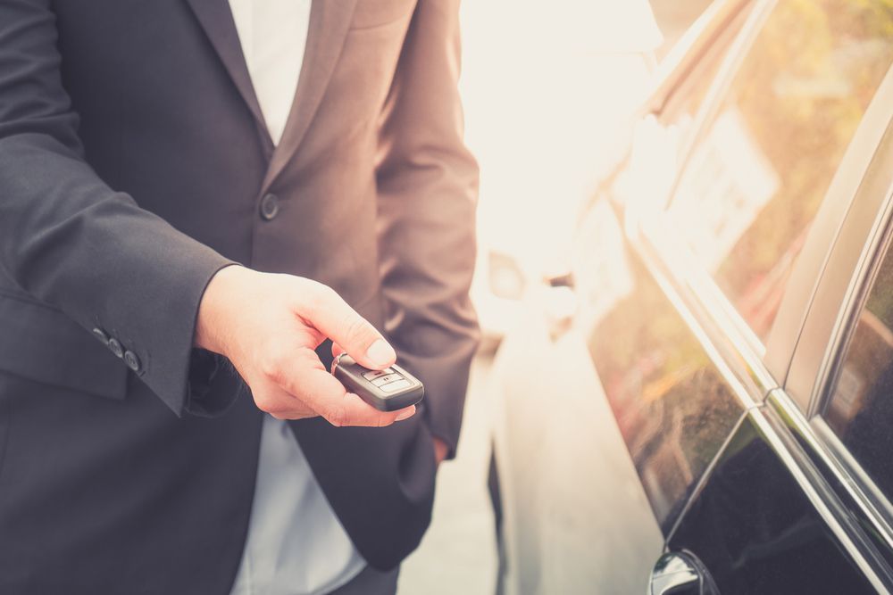 Businessman opens his luxurious car door with a modern remote control key. — Locksmith in Clear Island Waters, QLD