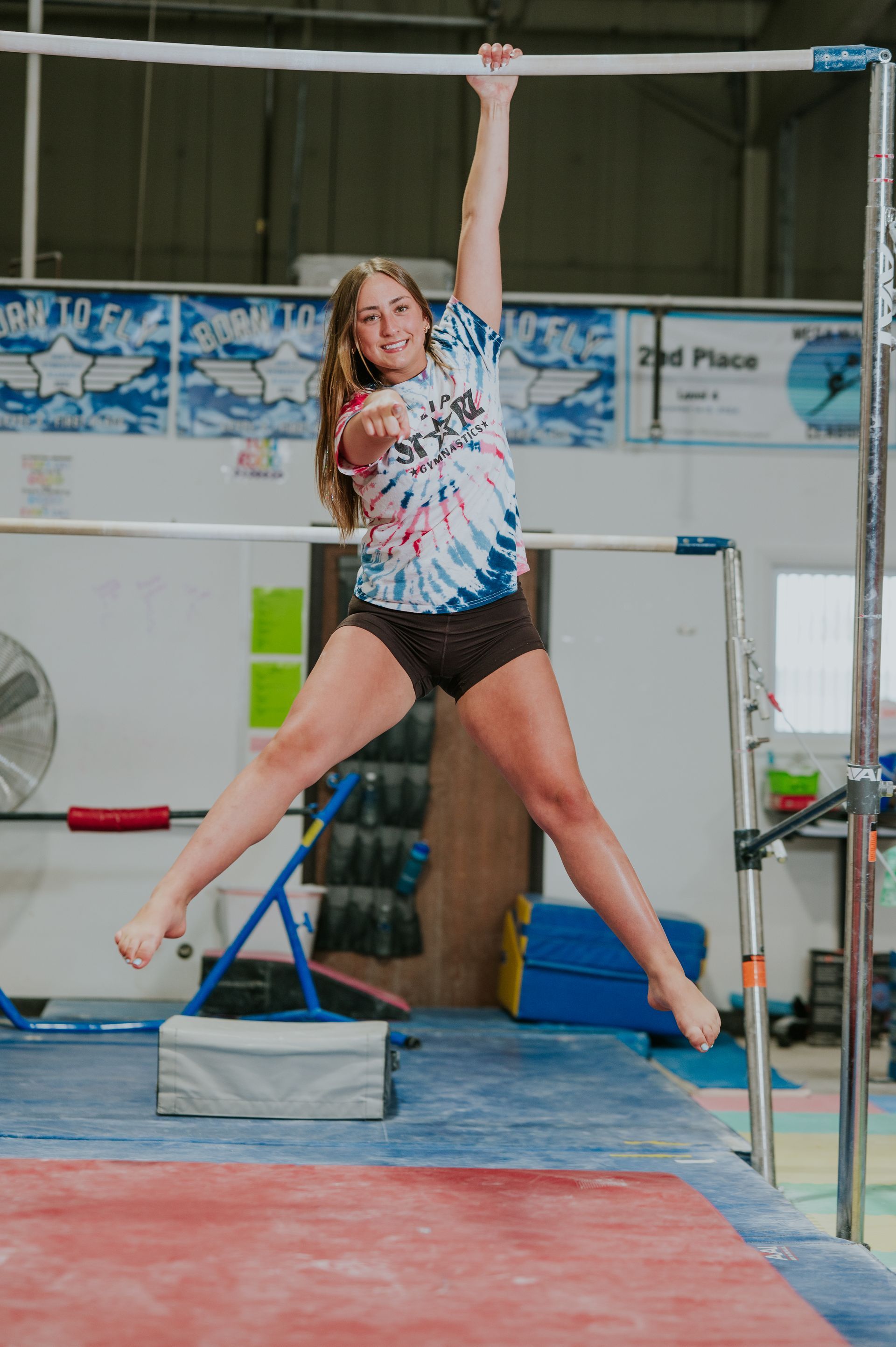 Athlete mid-air during a high jump attempt on an indoor track and field mat